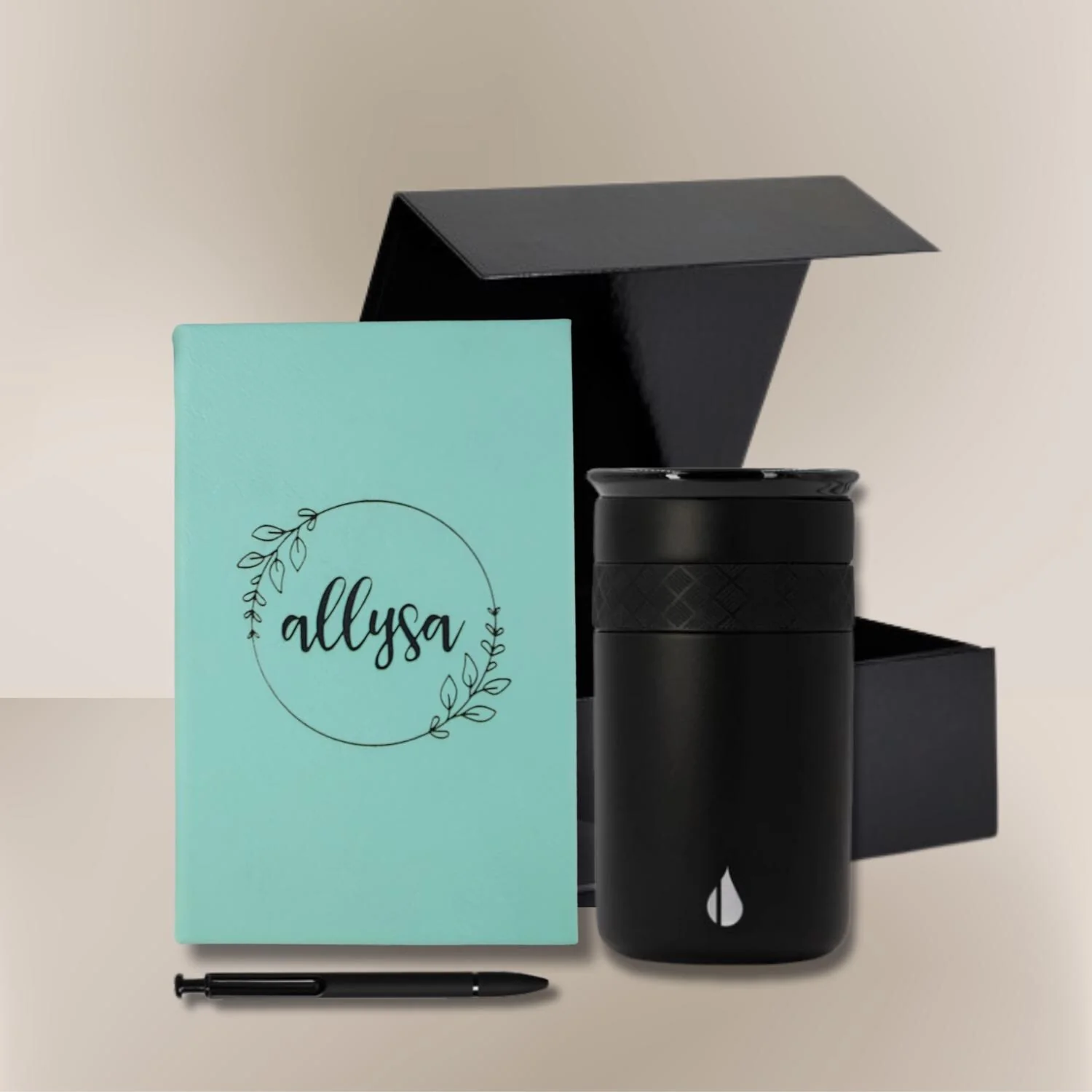 Essential gift set with personalized teal notebook, engraved black tumbler, and pen